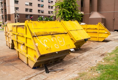 Workers sorting office furniture for recycling at a clearance site